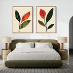 A modern bedroom with an olive green bed, white bedding, two beige nightstands with matching lamps, and two framed Rustic Stems Set of 2 minimalist leaf prints in olive green hanging above the headboard.