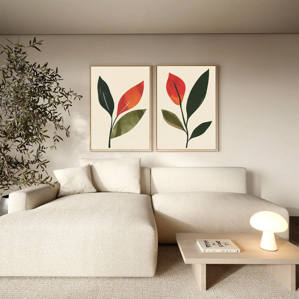 A modern living room features a cream sectional sofa, a minimal wooden coffee table with a glowing lamp, a potted plant, and the Rustic Stems Set of 2 framed olive green prints to enhance the contemporary decor.