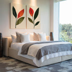 Modern bedroom with a large bed, white bedding, gray blanket, multiple pillows, two Rustic Stems Set of 2 prints above the bed, tall vases on each side, and a large window overlooking greenery.