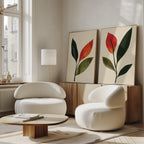 A modern living room with two white armchairs, a wooden coffee table, a floor lamp, and the Rustic Stems Set of 2 olive green leaf prints displayed on a sideboard by tall windows.