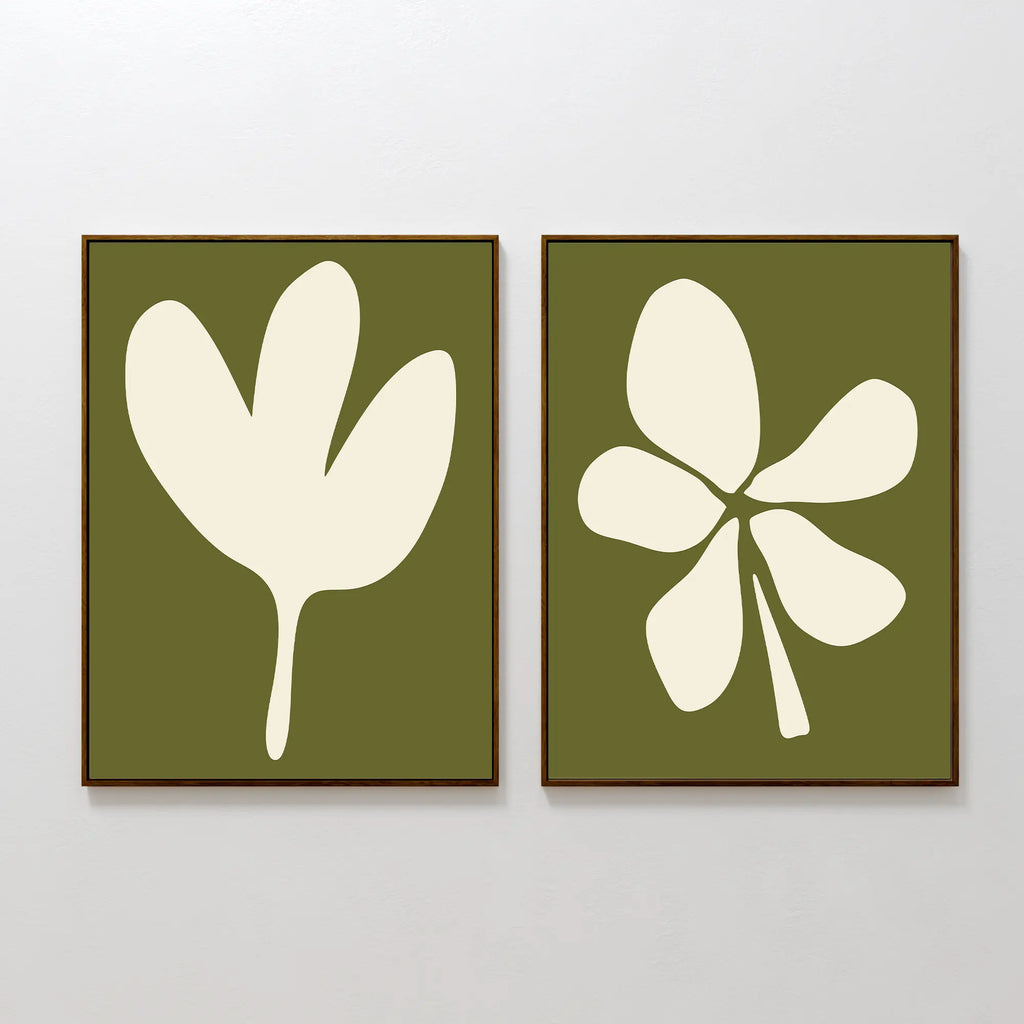 The Sage Petal Set of 2 features framed wall art prints on a white wall with cream floral silhouettes on sage green backgrounds—one print shows a three-lobed leaf, the other highlights a five-lobed leaf.