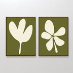 The Sage Petal Set of 2 features framed wall art prints on a white wall with cream floral silhouettes on sage green backgrounds—one print shows a three-lobed leaf, the other highlights a five-lobed leaf.