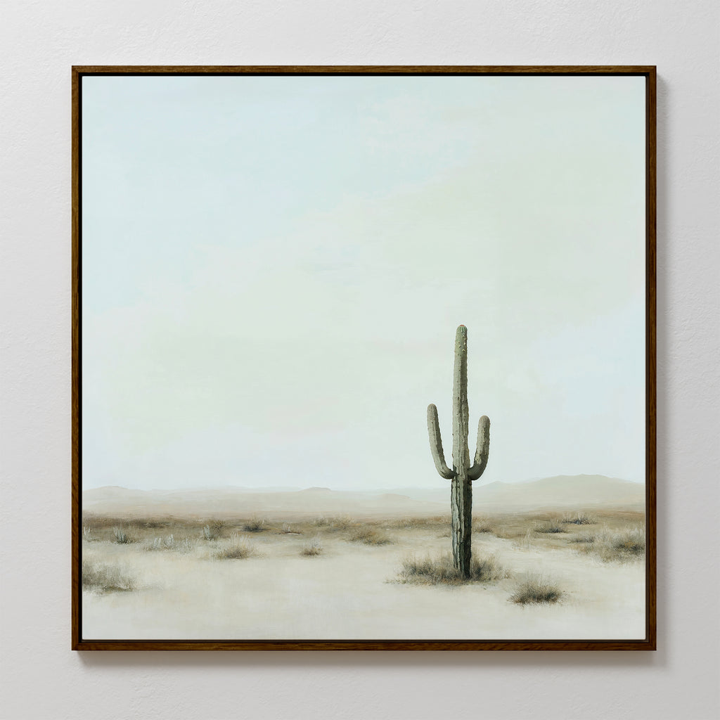 The Saguaro Whisper Canvas Art is a framed minimalist wall piece depicting a single tall saguaro cactus in a desert landscape, with soft muted tones and a pale sky, capturing serene simplicity for your space.