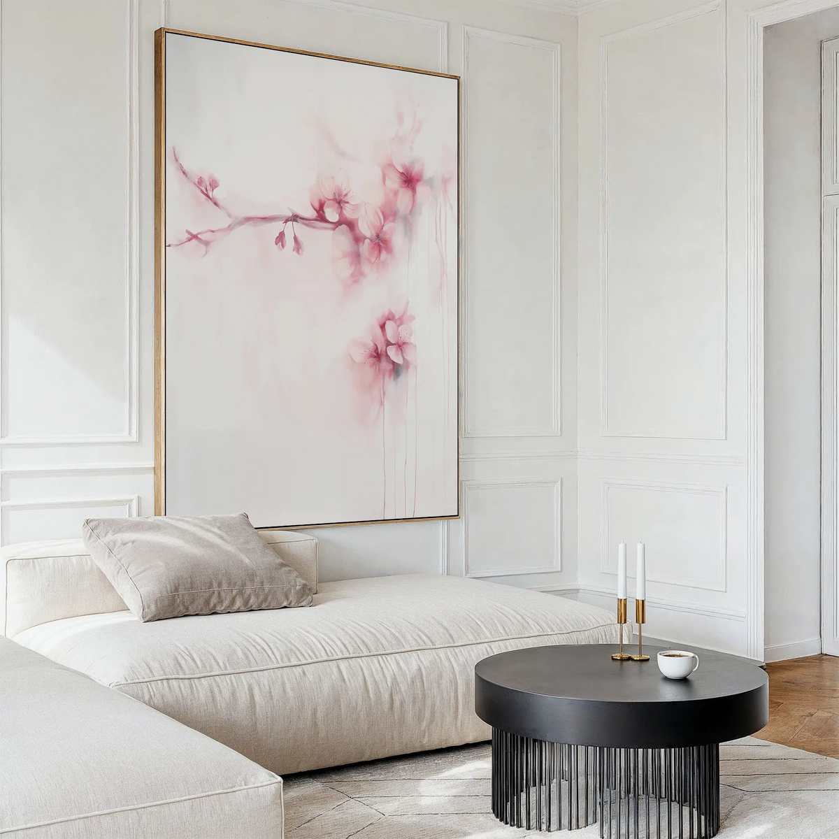 A modern living room featuring a light beige sectional sofa, a round black coffee table, and the Sakura Dream Canvas Art with pink flowers. The decor is minimal and bright, highlighting neutral tones for a serene ambiance.