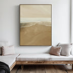 A minimalist living room with light wood furniture, white cushions, and the Sand and Sea Abstract Canvas Art in beige and cream tones hanging on a white wall above a corner bench.