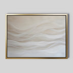 The Sandy Hues Abstract Canvas Art features soft beige and white wave shapes on a light background, evoking calm. Framed in gold with black accents, this minimalist piece is ideal for living room decor.