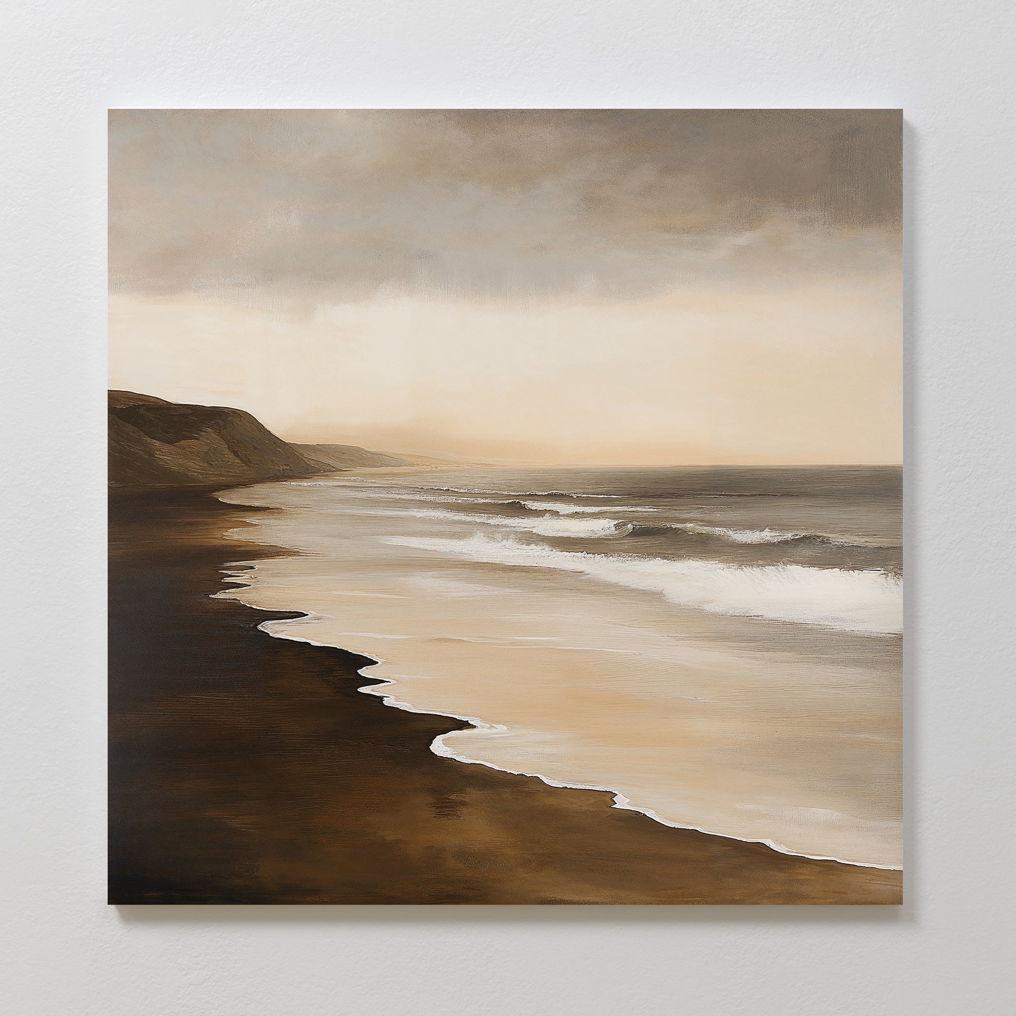 The Sandy Shoreline Canvas Art features gentle waves, a dark sandy beach, distant cliffs, and a cloudy sky in earthy tones—ideal coastal wall art or beach scene canvas for enhancing your living room decor.