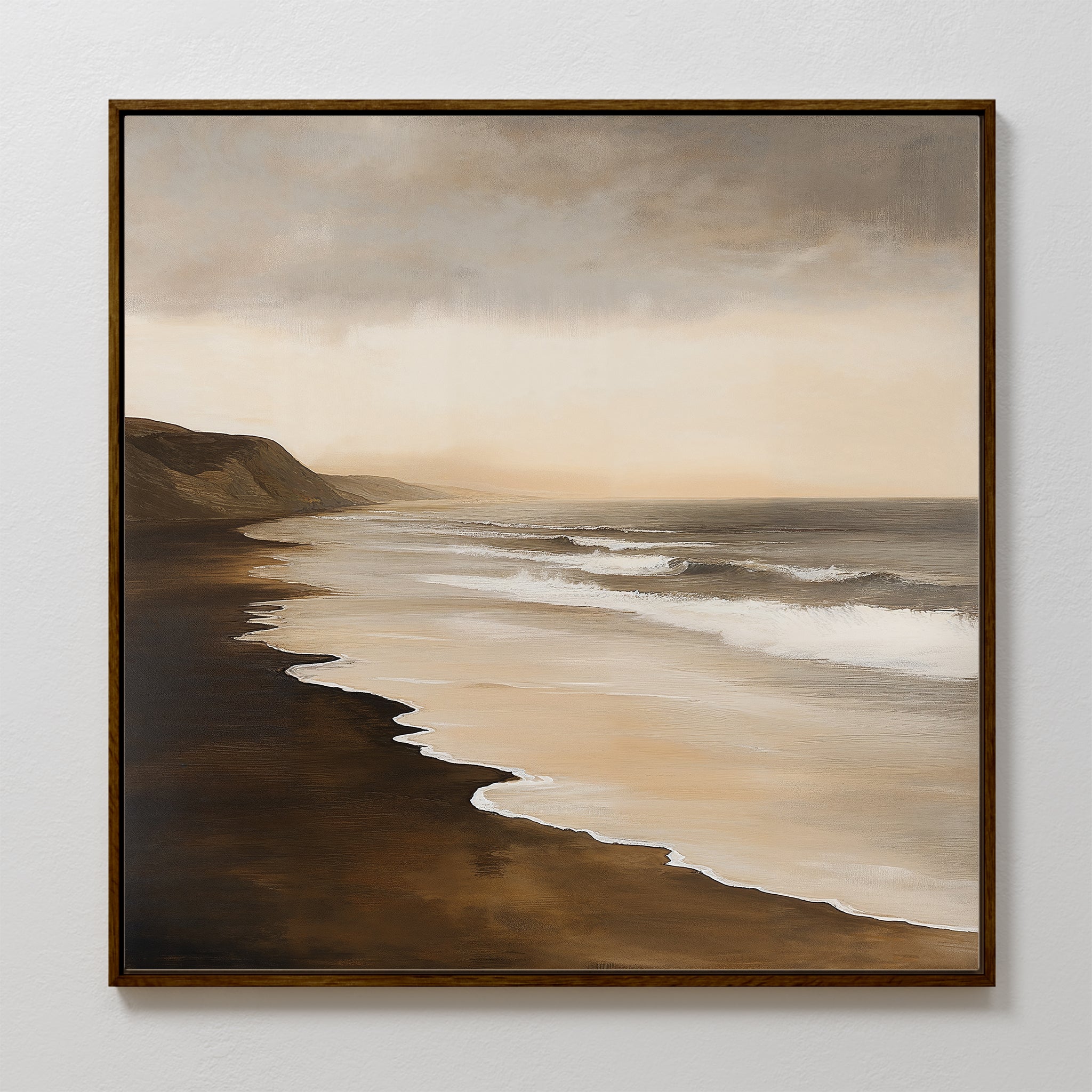 The Sandy Shoreline Canvas Art showcases a tranquil beach with gentle waves, dark sand, and misty cliffs beneath a cloudy sky in soft brown and beige—ideal for adding calming style to your living room.