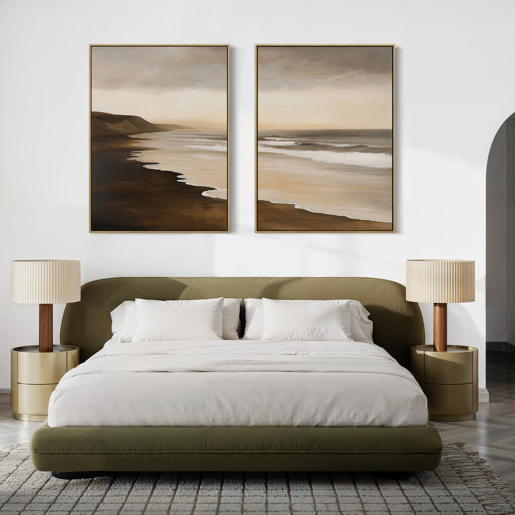 A modern bedroom features a green upholstered bed with white bedding, two beige nightstands with matching lamps, and the Sandy Shoreline Set of 2 canvas above the bed, set against a white wall.