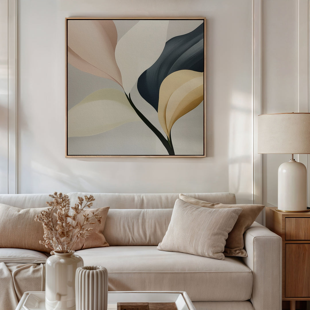 A modern living room with a beige sofa, neutral pillows, a lamp, and dried flowers features Sculpted Elegance Canvas Art—a minimalist botanical piece in muted tones—hung above the couch for an elegant décor accent.
