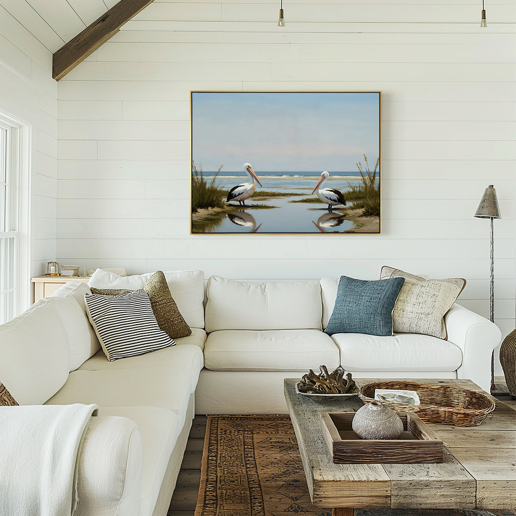 Bright, airy living room with white shiplap walls, a large white sectional, rustic wooden coffee table, and the Seaside Gaze Canvas Art featuring two pelicans by the water for a serene coastal vibe.