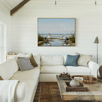 Bright, airy living room with white shiplap walls, a large white sectional, rustic wooden coffee table, and the Seaside Gaze Canvas Art featuring two pelicans by the water for a serene coastal vibe.
