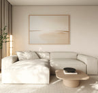 Minimalist living room decor features a light beige sectional sofa, the Serene Expanse Canvas Art – Horizontal above, a small wooden coffee table with a dark bowl, and a tall plant in the corner; soft natural light filters through curtains.