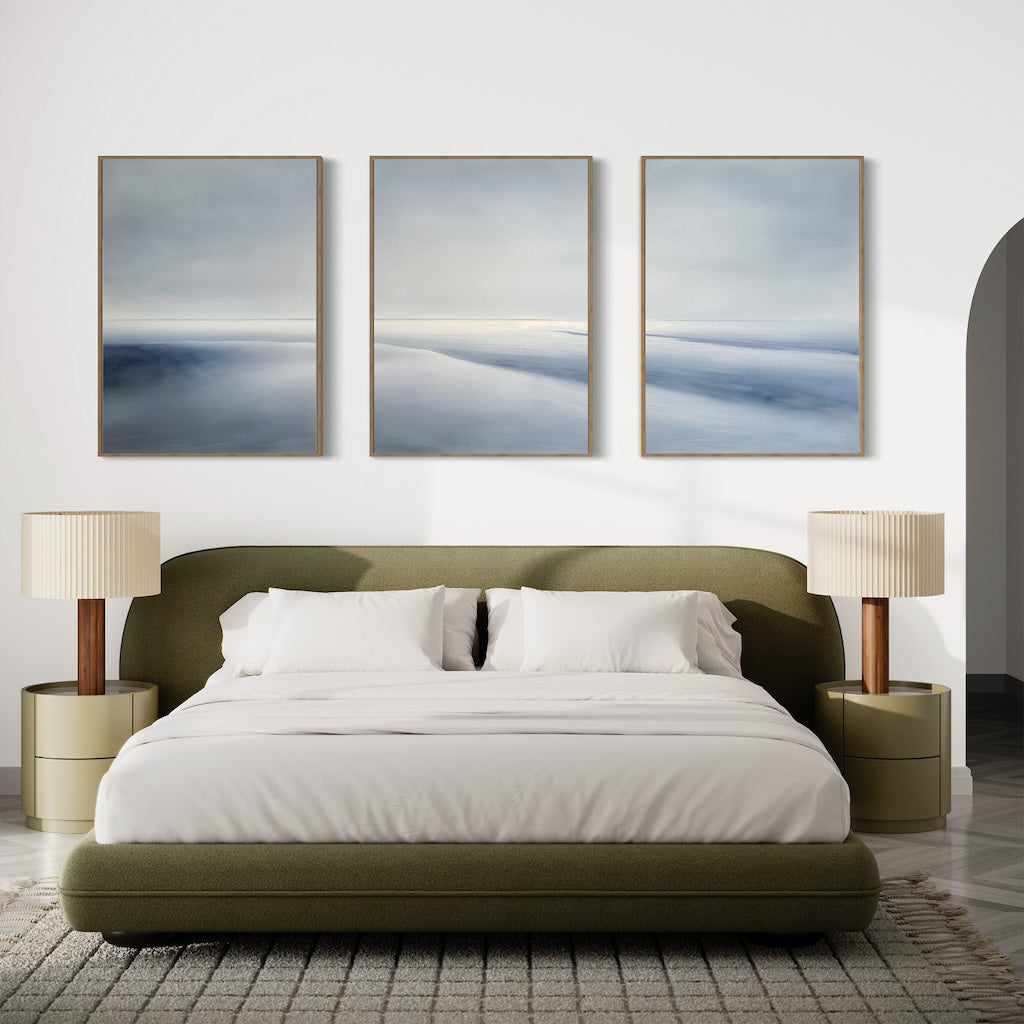 A modern bedroom with a green upholstered bed, white bedding, two round nightstands, and the Serene Horizons Set of 3 abstract landscape paintings above the bed creates a tranquil retreat.