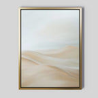 The Serene Peaks Abstract Canvas Art features a gold-framed painting of soft sand dunes in beige and cream beneath a pale, cloudy sky, creating a calm, minimalist landscape.