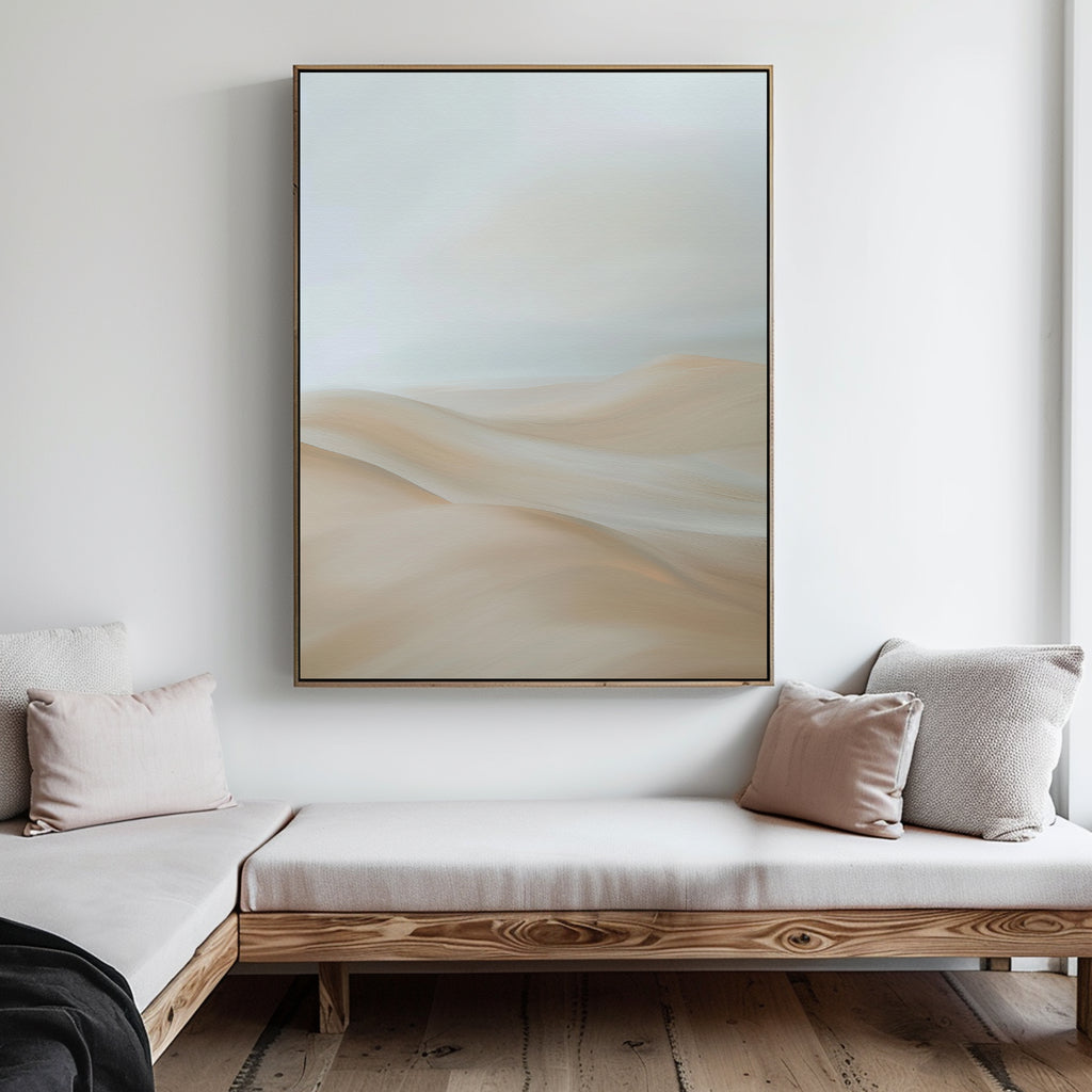 A minimalist living room with light wooden furniture, beige and white cushions, and the Serene Peaks Abstract Canvas Art depicting soft sand dunes on the wall. The space is bright and uncluttered.