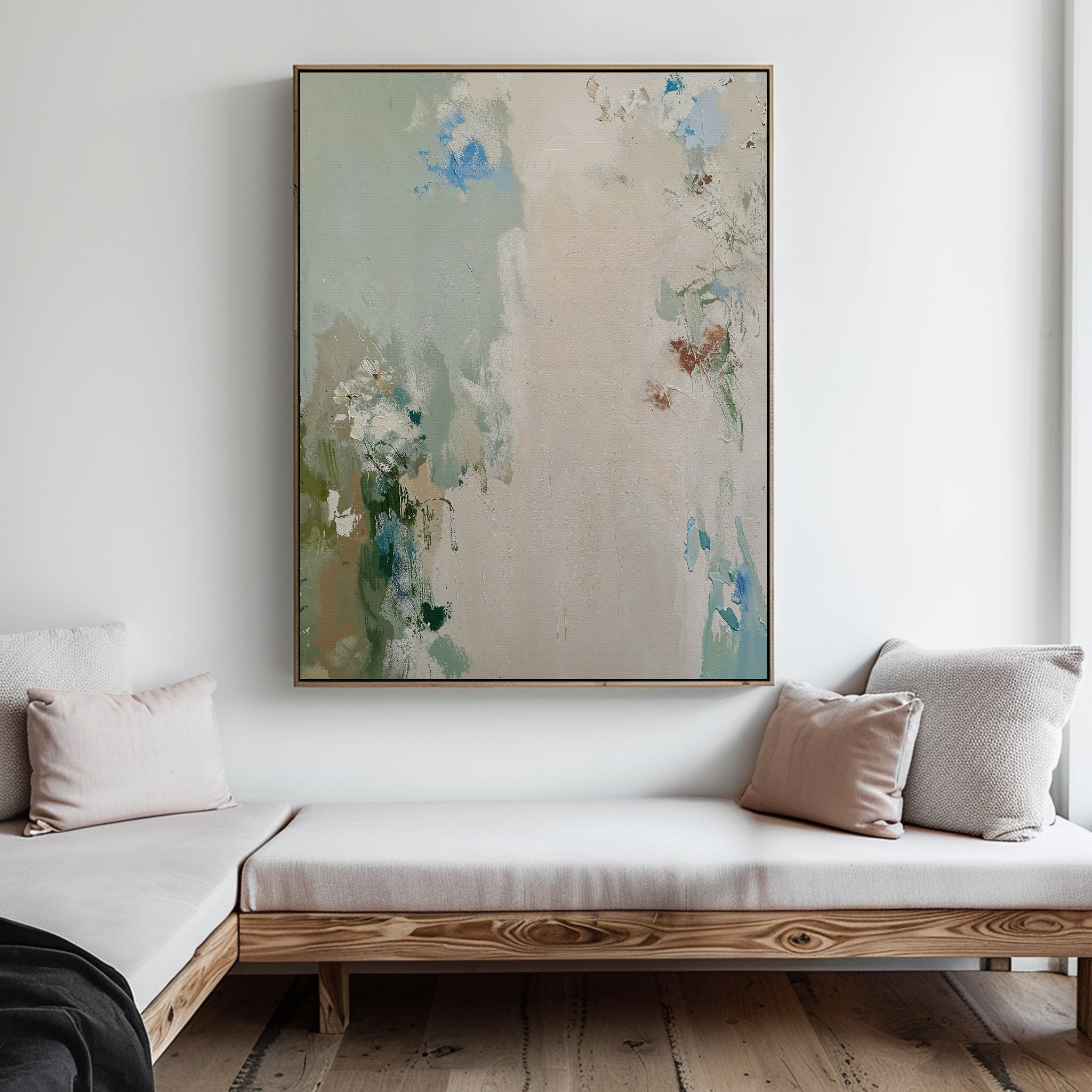 Serenity Garden Abstract Canvas Art, featuring soft green, blue, and beige tones, hangs on a white wall above a wooden bench with light cushions.