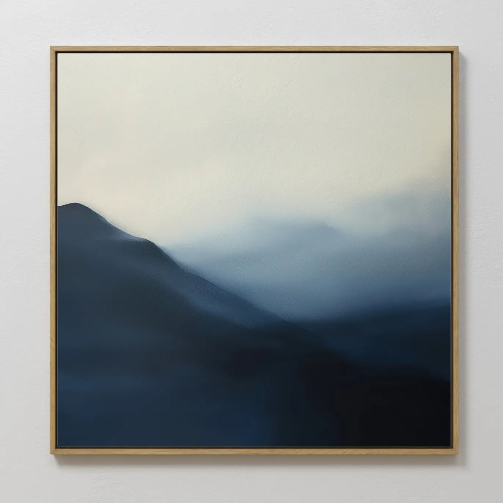 Shadowed Valley Canvas Art is a framed abstract wall art featuring misty blue mountains fading into a pale, cloudy sky. Its minimalist design with soft gradients creates a calm and serene atmosphere for any space.