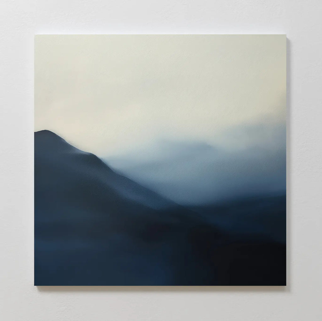 Shadowed Valley Canvas Art features a minimalist painting of misty blue and gray mountains with soft edges and a pale sky, creating a tranquil, serene atmosphere—perfect for calming decor.