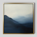 Shadowed Valley Canvas Art features abstract misty blue mountains fading into a foggy sky. Soft edges create a tranquil, minimalist landscape, while the simple metallic gold frame adds elegance—perfect for calming décor.