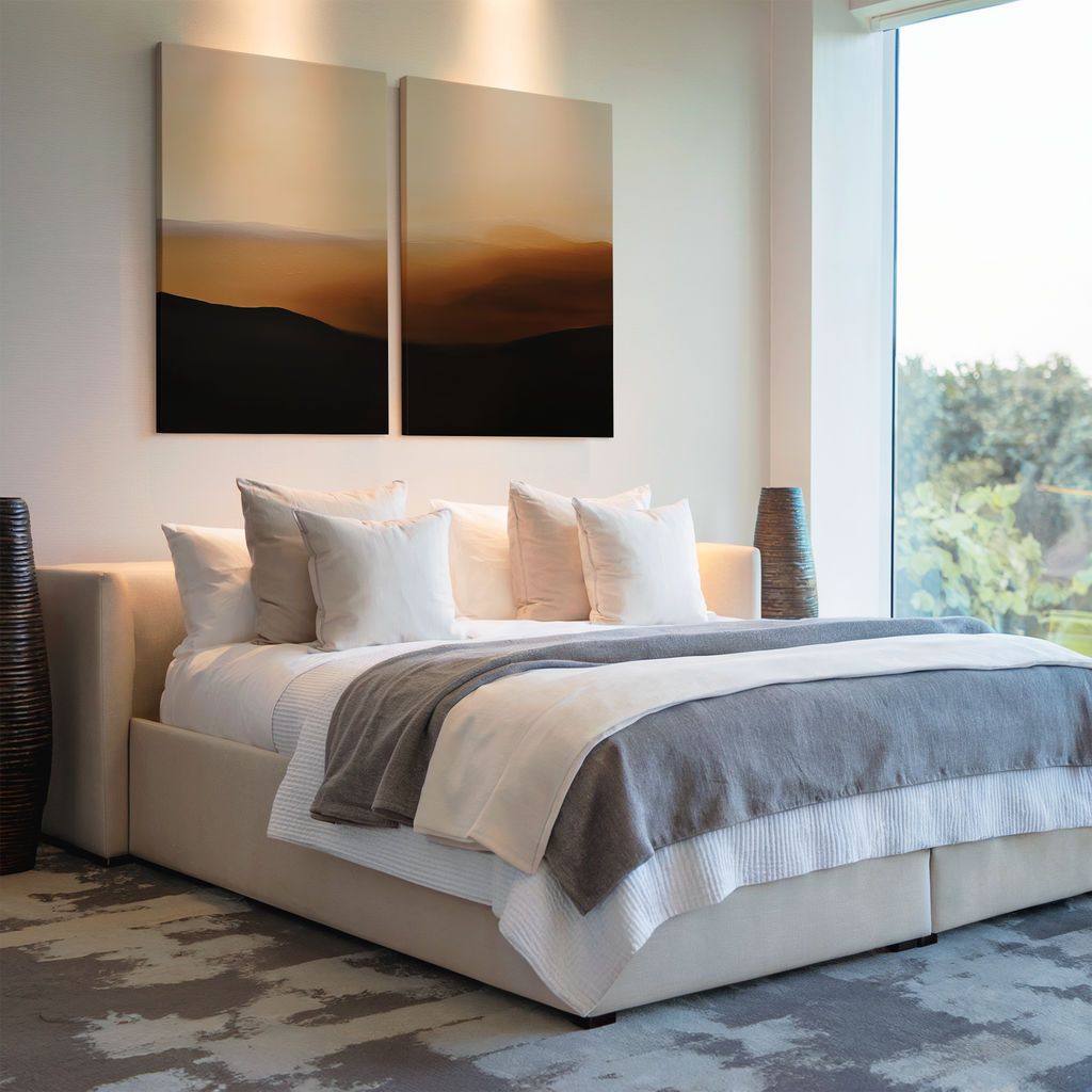 A modern bedroom with a large bed with white and gray bedding, several pillows, Sienna Echo Set of 2 wall art above the headboard, floor vases on each side, and a large window letting in natural light.