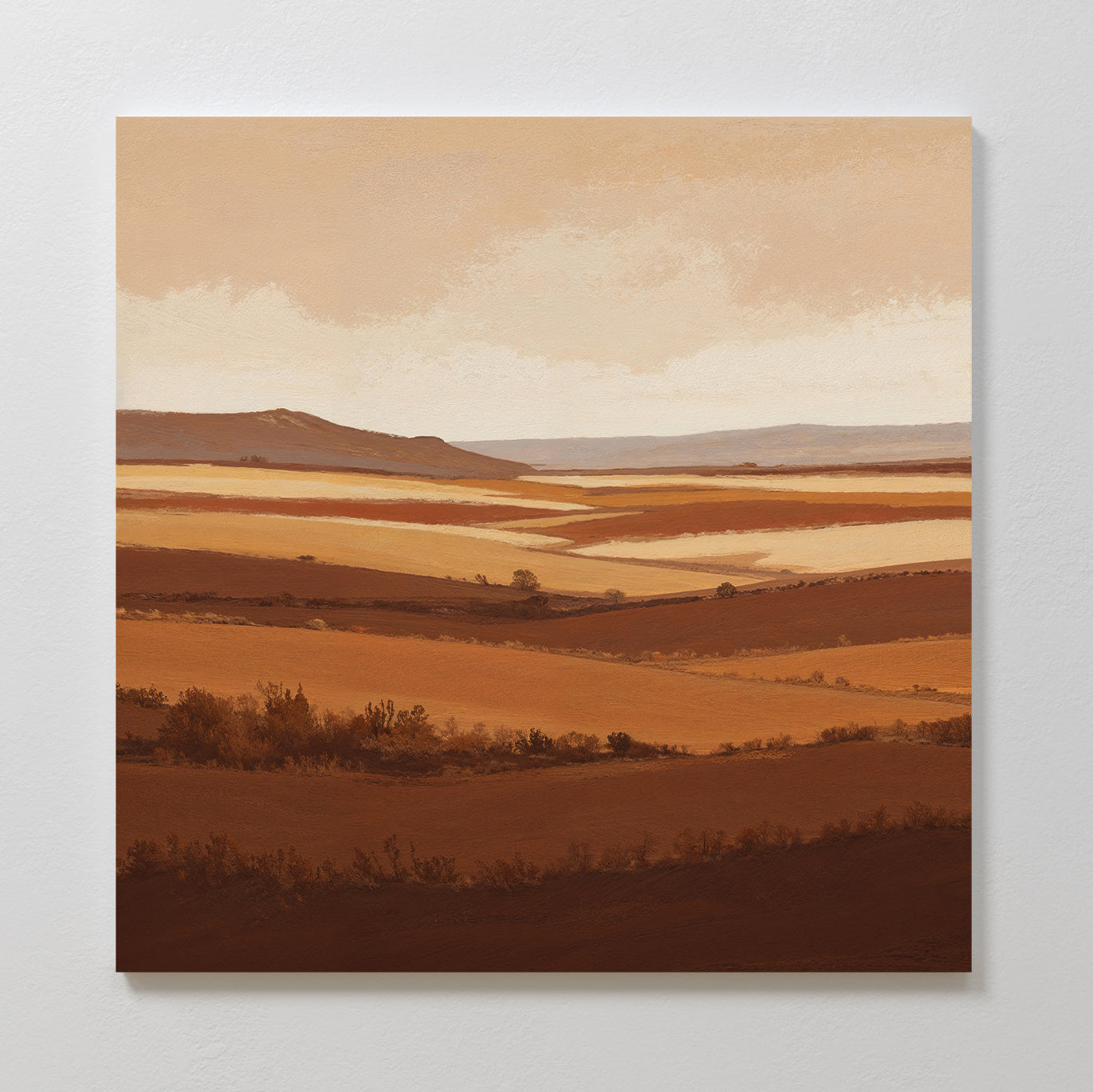 The Sienna Terrain Canvas Art features rolling hills and fields in warm brown and beige tones beneath a soft sky, capturing an earthy, layered landscape thats perfect for creating a calming Nordic Park vibe in your space.