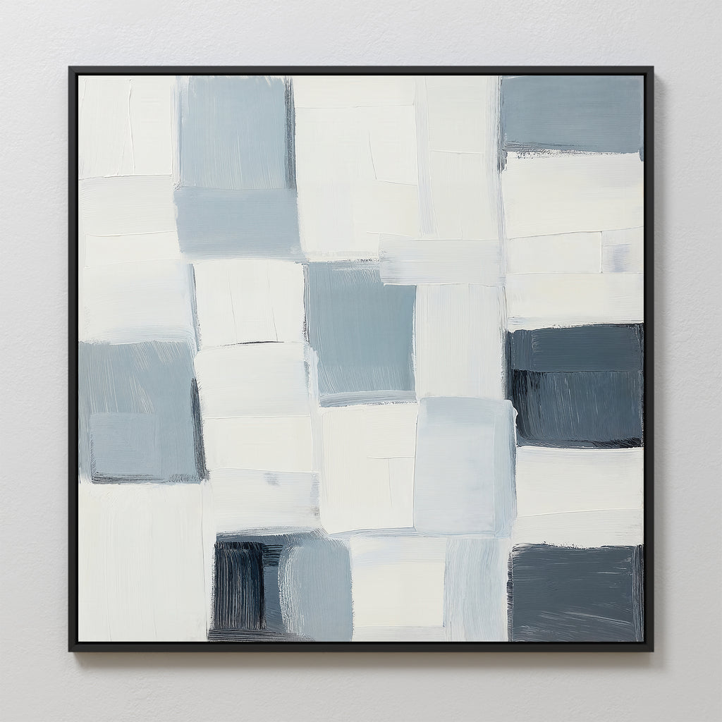 Silent Squares Abstract Canvas Art features a grid of overlapping white, grey, and blue rectangles, creating a textured geometric pattern. This minimalist wall art is framed in black and displayed on a light-colored wall.