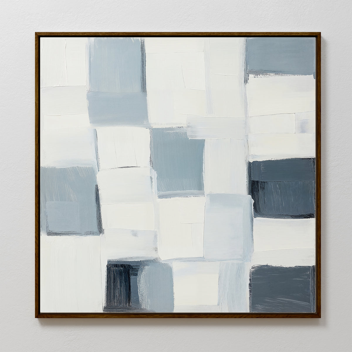 Silent Squares Abstract Canvas Art showcases a grid of overlapping rectangles in white, light blue, and gray with visible brushstrokes. This minimalist wall art features a thin dark frame and is displayed on a light-colored wall.