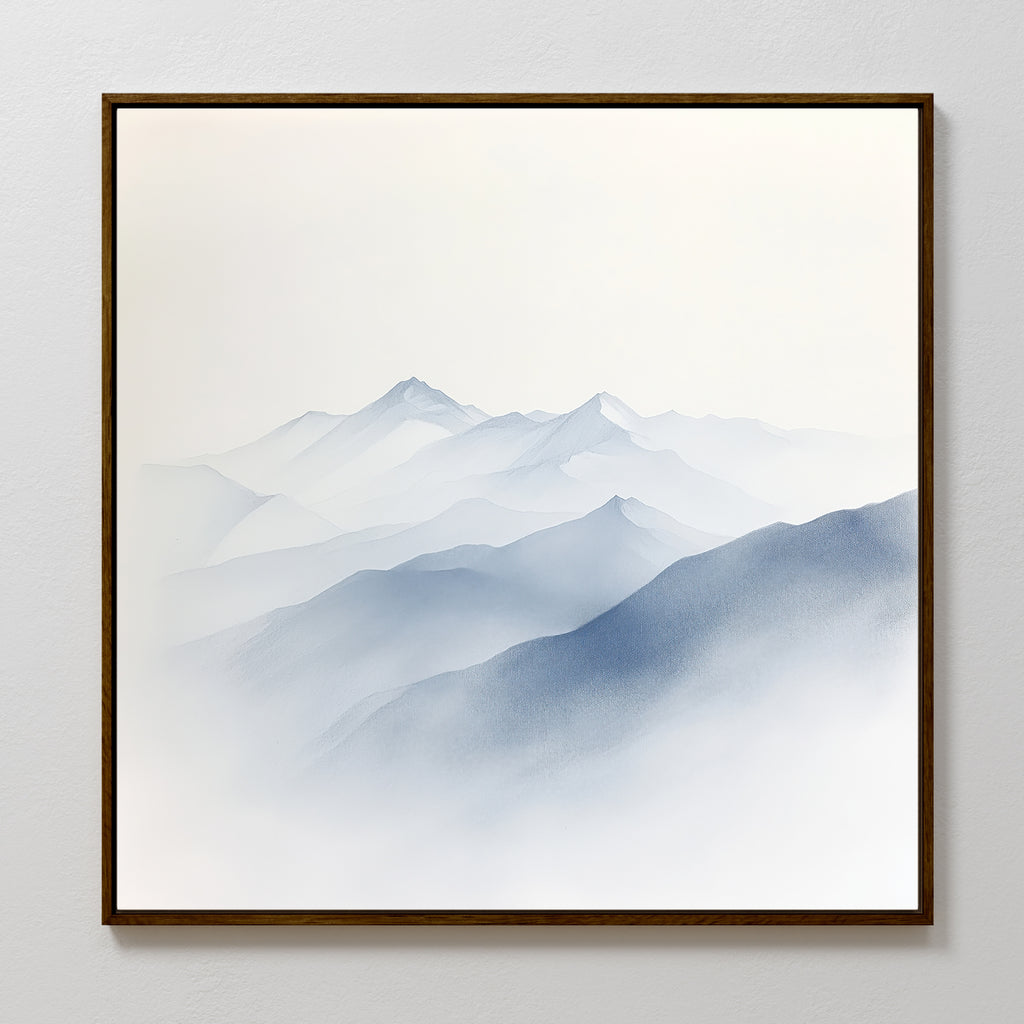Silent Summits Canvas Art features layered blue-gray mountains in mist and fog, creating a serene atmosphere. Elegantly framed, it hangs beautifully on a white wall—ideal for bringing calm to any bedroom décor.