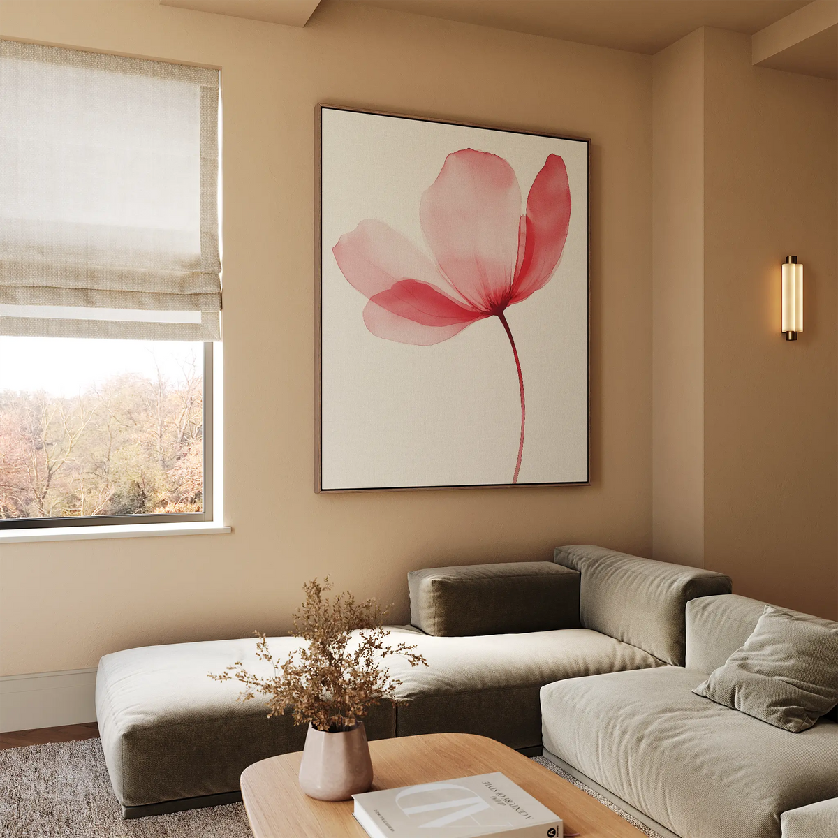 A cozy, modern living room features a light taupe sectional sofa, a wooden coffee table with a vase of dried flowers, and the Single Bloom Canvas Art in blush pink. Sunlight streams in through a window with a beige Roman shade.