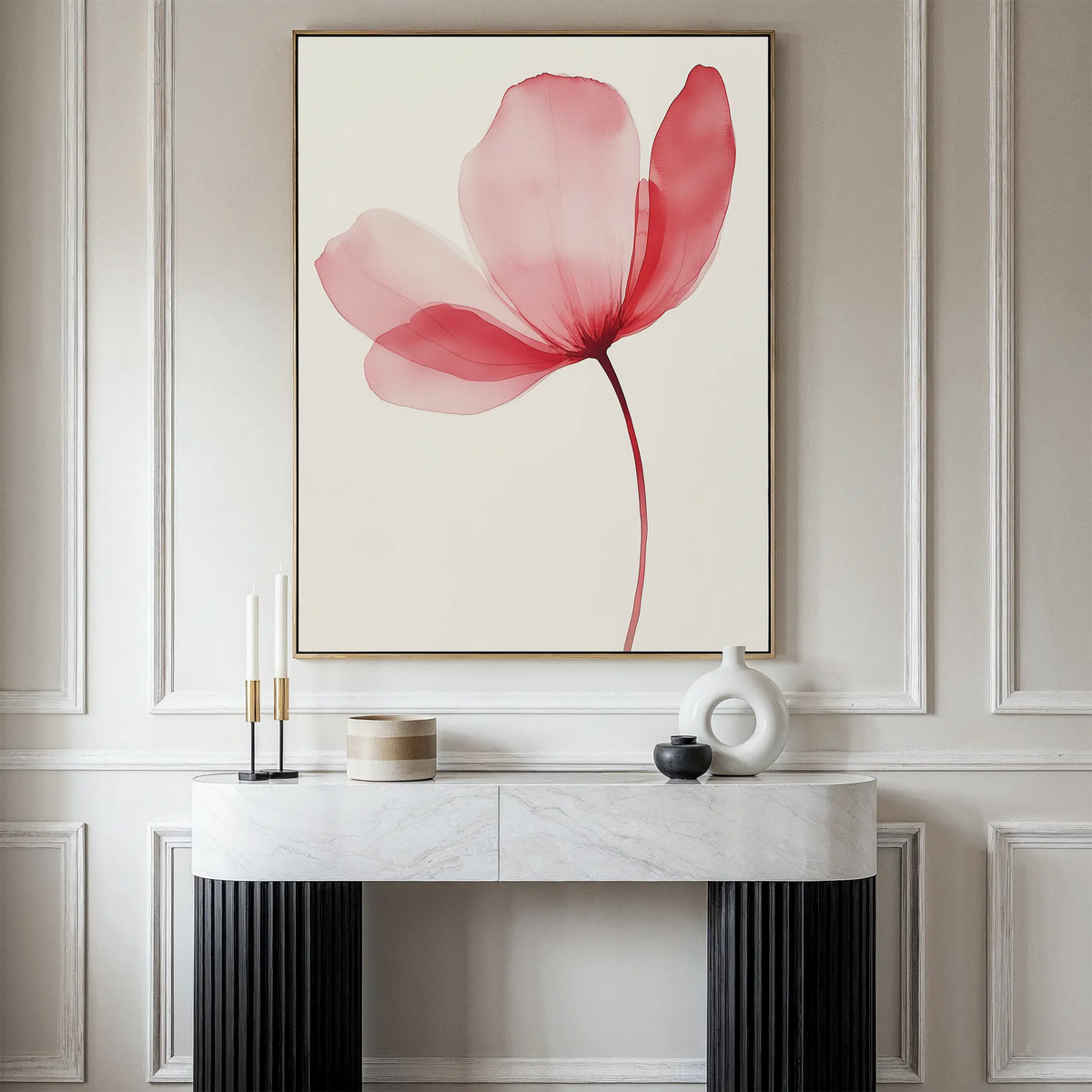 A minimalist console table with decorative objects stands against a wall, above which hangs the Single Bloom Canvas Art featuring a single pink flower with delicate, translucent petals on a light background.