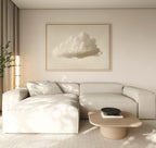 A minimalist living room features a light beige sectional sofa, low wooden coffee table, and modern decor. The Singular Vapor Canvas Art – Horizontal hangs above, while natural light and a potted plant complete the airy space.