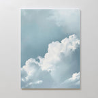 Sky Serenade Abstract Canvas Art features soft, fluffy white clouds against a light blue sky on a plain white wall, adding a serene, airy touch to your living room decor with its minimalist design.