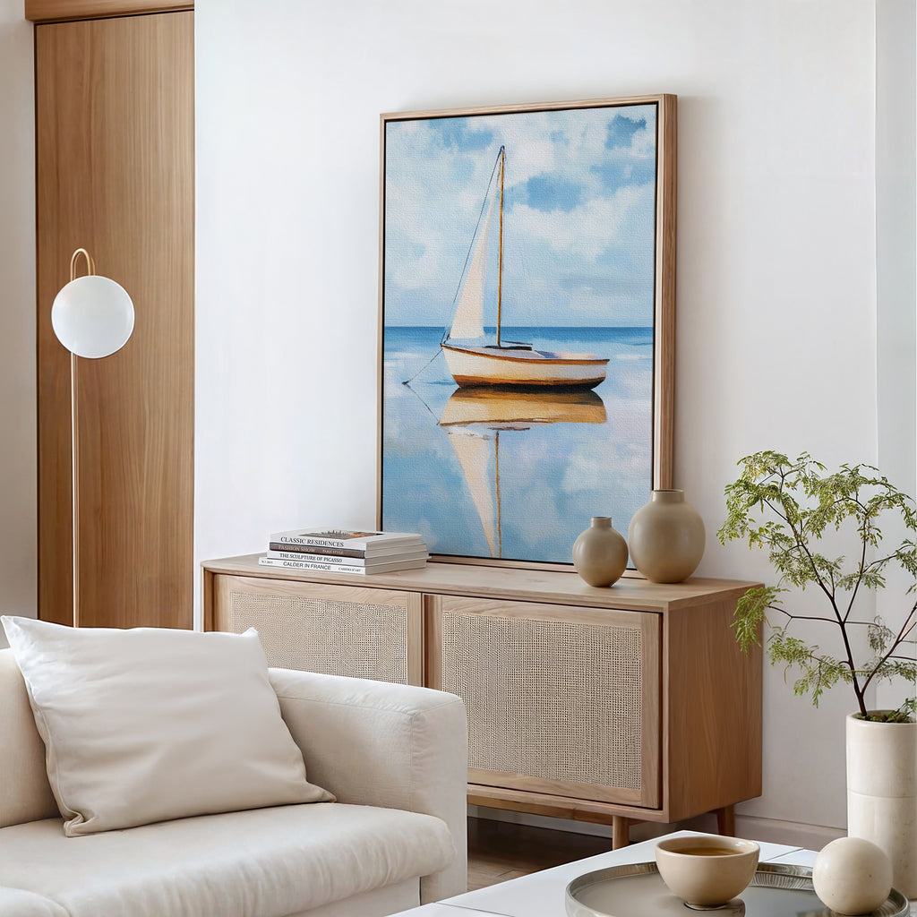 A modern living room with a white sofa, wooden sideboard, books and vases, minimalist wall art featuring the Skybound Reflection Canvas Art, a round white pendant lamp, and a small potted plant on the table.