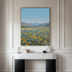 The Skyview Field Canvas Art, featuring a vibrant wildflower field with distant mountains and blue sky, hangs above a modern white and black console table in an elegant paneled room with minimalist decor.