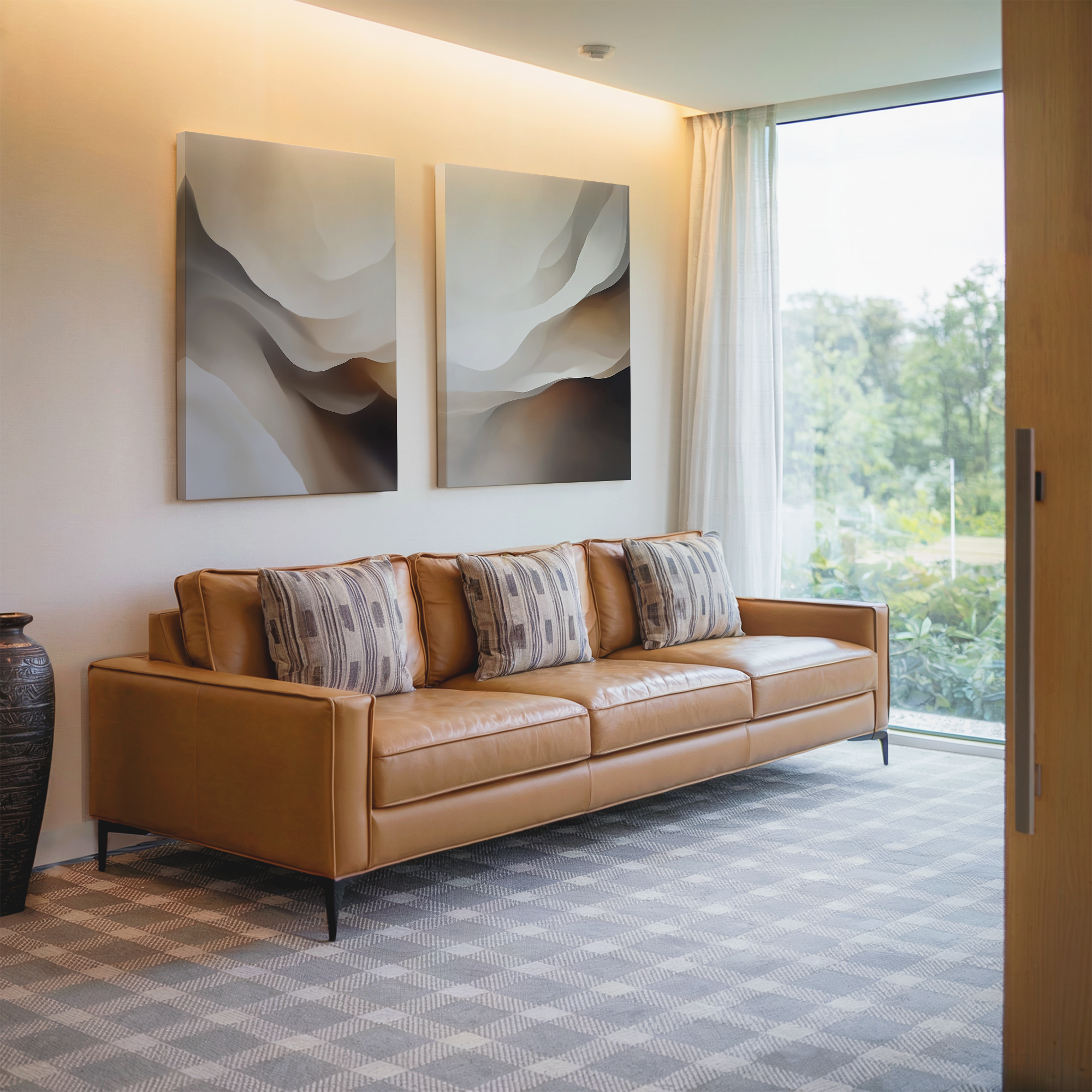 A modern living room featuring the Smooth Flow Set of 2 wall art prints above a tan leather sofa with patterned cushions, sheer curtains on a large window, a tall vase on a patterned carpet, and lush greenery visible outside.