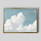 The Soaring Peace Canvas Art features fluffy white clouds in a serene sky, framed in gold and displayed on a light gray wall—an ideal choice for vintage decor lovers.