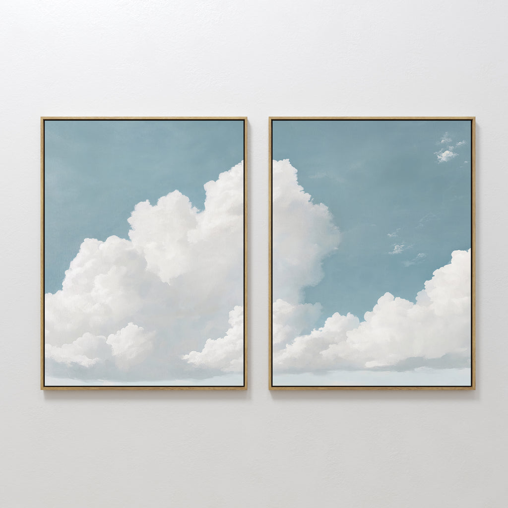 The Soaring Peace Set of 2 features framed prints of a blue sky and fluffy white clouds, bringing a calm and serene touch to any plain white wall.
