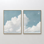 The Soaring Peace Set of 2 features framed prints of a blue sky and fluffy white clouds, bringing a calm and serene touch to any plain white wall.