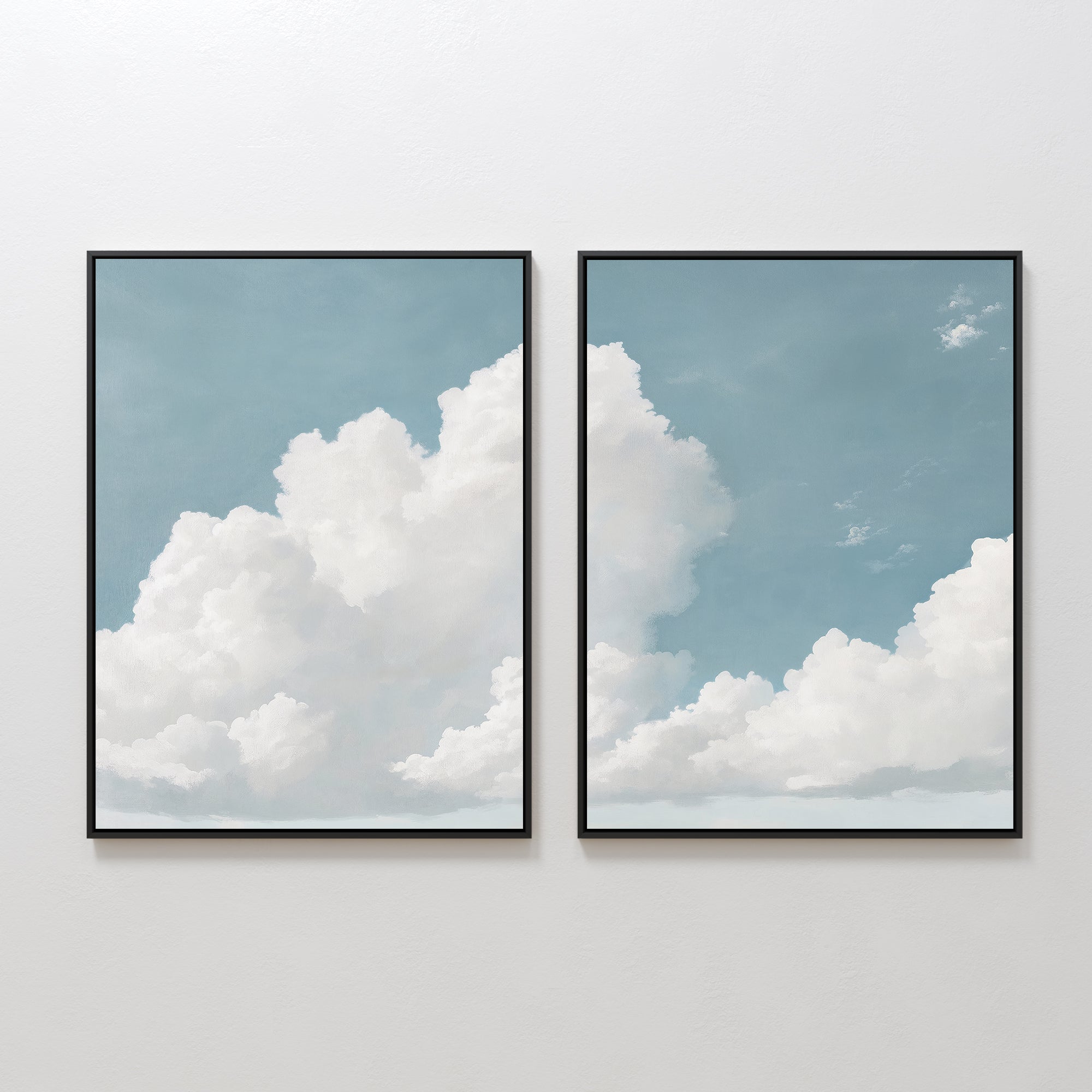 The Soaring Peace Set of 2 features framed wall art prints of white clouds on a blue sky, displayed side by side. The tranquil design flows across both frames for a cohesive, calming effect on any plain white wall.