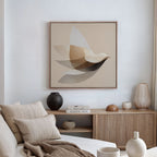 A minimalist living room with a neutral palette, featuring a beige sofa with cushions, a wooden sideboard with decorative items, and the Soaring Stillness Canvas Art in an abstract design above the sideboard.