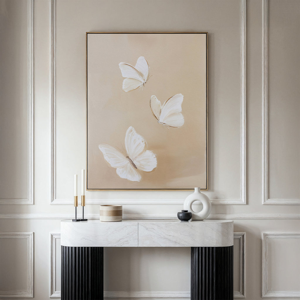 A minimalist room features a marble console table and decorative objects beneath Linen Wings Canvas Art on a beige background, set against cream-paneled walls—a perfect display of Nordic Park-inspired elegance.