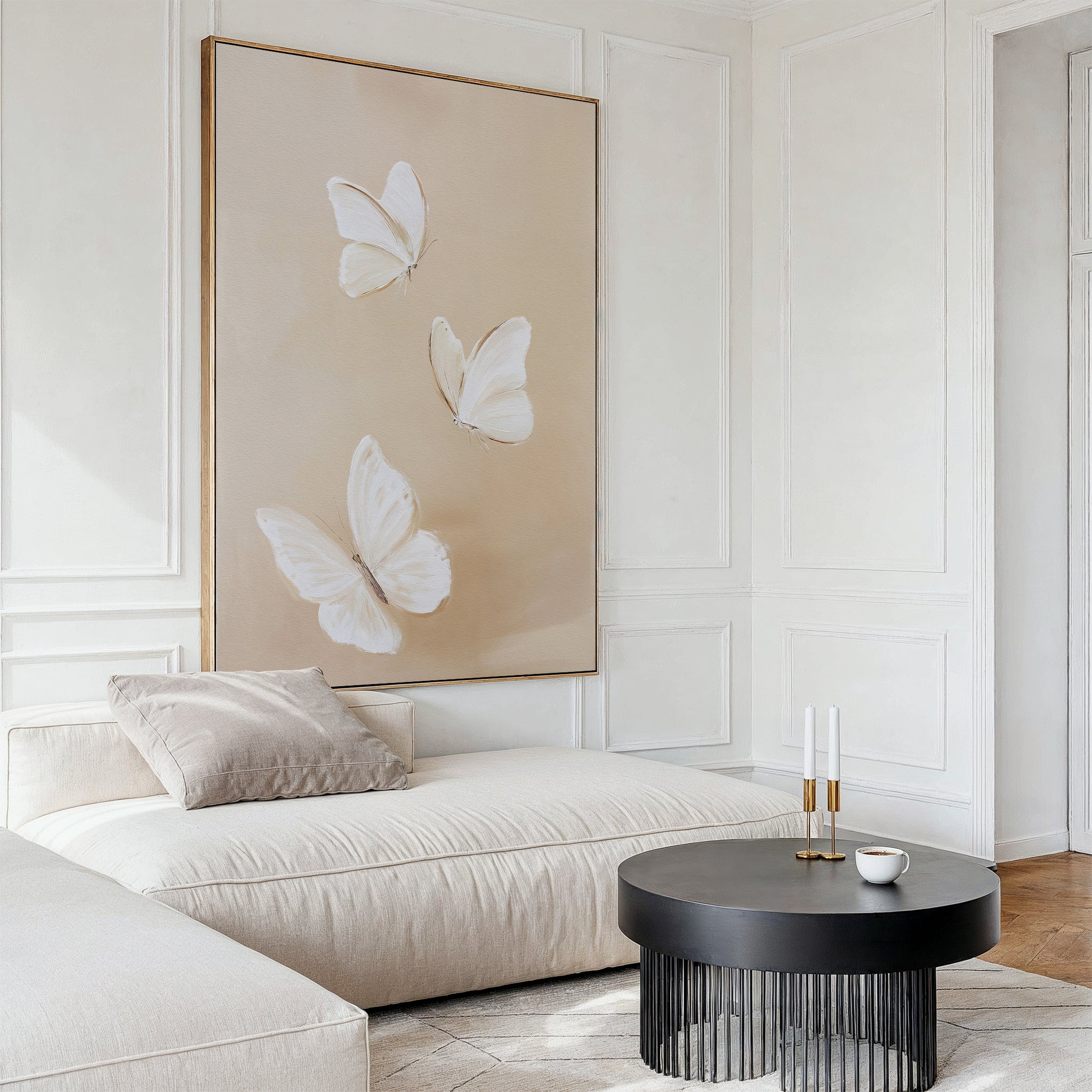 A modern living room features a large beige sofa, a round black coffee table with a cup and candles, and the Linen Wings Canvas Art on a beige background. White paneled walls enhance the Nordic Park-inspired aesthetic.