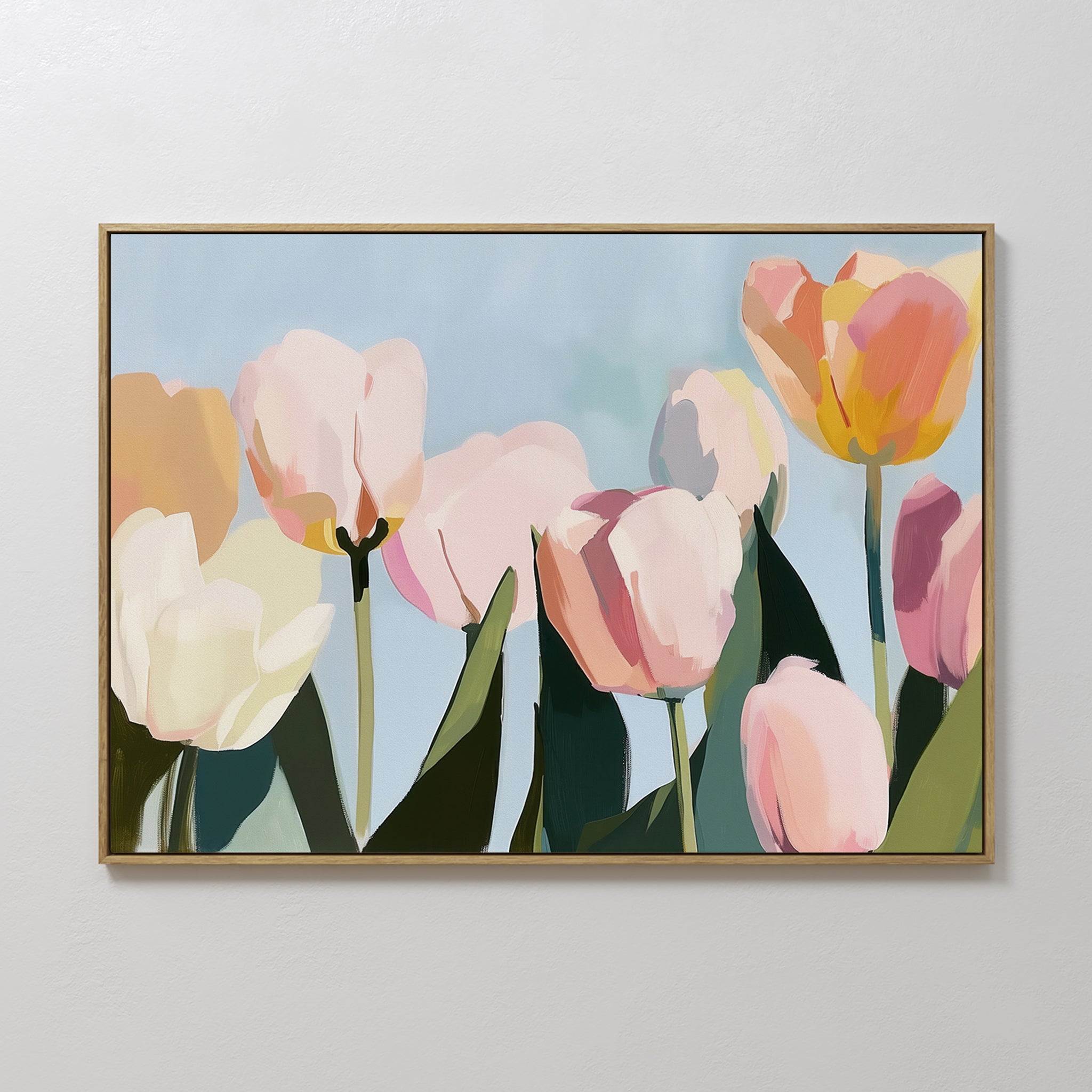The Soft Field Canvas Art features tulips in pastel pink, yellow, and white with green leaves on a light blue background, adding minimalist elegance to any plain white wall.