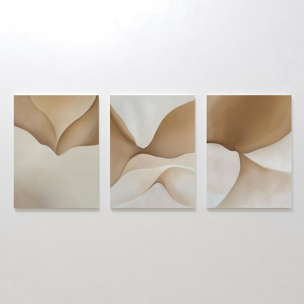 The Soft Sands Set of 3 features abstract canvases with flowing shapes in beige, tan, and cream tones, displayed side by side. This minimalist wall art brings a calming ambiance with its organic forms and neutral palette.