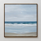 The Soft Tide Canvas Art features a serene seascape with gentle waves, cloudy sky, and sandy beach in soft blue, gray, and beige—ideal coastal decor to enhance any plain white wall.