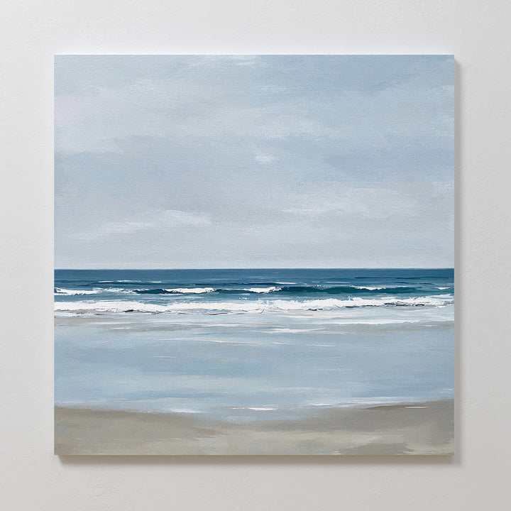 Soft Tide Canvas Art captures a tranquil beach scene with gentle waves and a cloudy sky in soft blue, gray, and beige tones—ideal canvas art for adding coastal decor to your space.