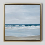 The Soft Tide Canvas Art features a calm beach scene with gentle waves, a sandy shore, and a cloudy sky in soft blue and beige. It’s elegantly framed in gold with a black inner edge, making it perfect coastal decor for any space.