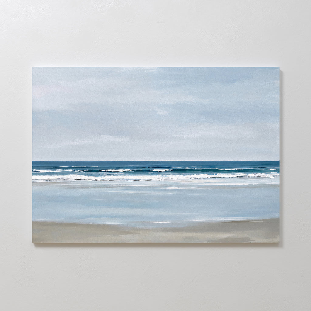 The Soft Tide Canvas Art – Horizontal features a calm beach with gentle waves and a soft blue sky, using muted blues, whites, and sandy beige. It’s perfect minimalist wall art for adding tranquil coastal vibes to your bedroom decor.
