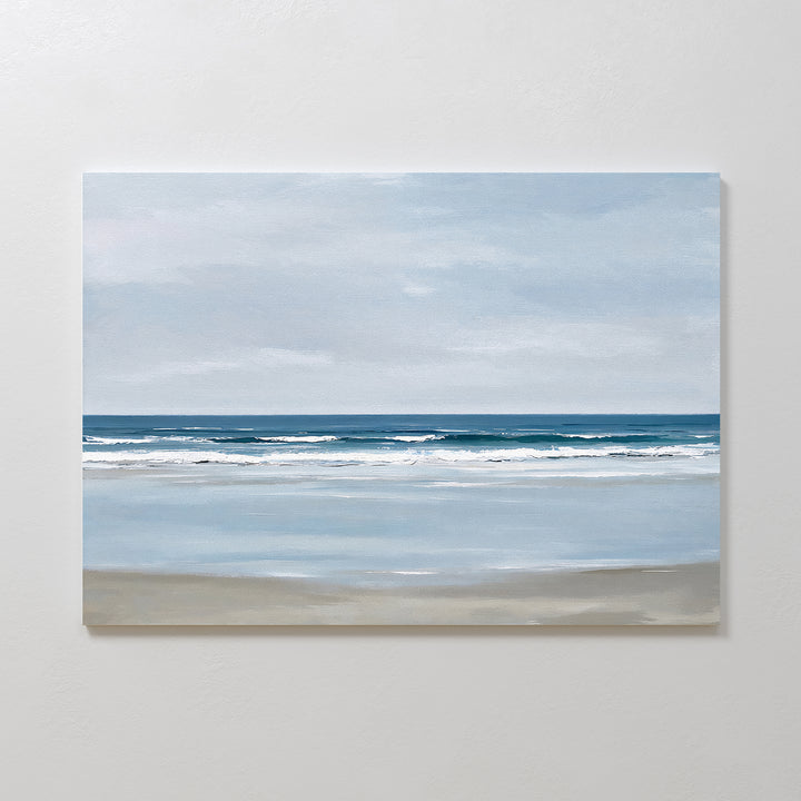 The Soft Tide Canvas Art – Horizontal features a calm beach with gentle waves and a soft blue sky, using muted blues, whites, and sandy beige. It’s perfect minimalist wall art for adding tranquil coastal vibes to your bedroom decor.